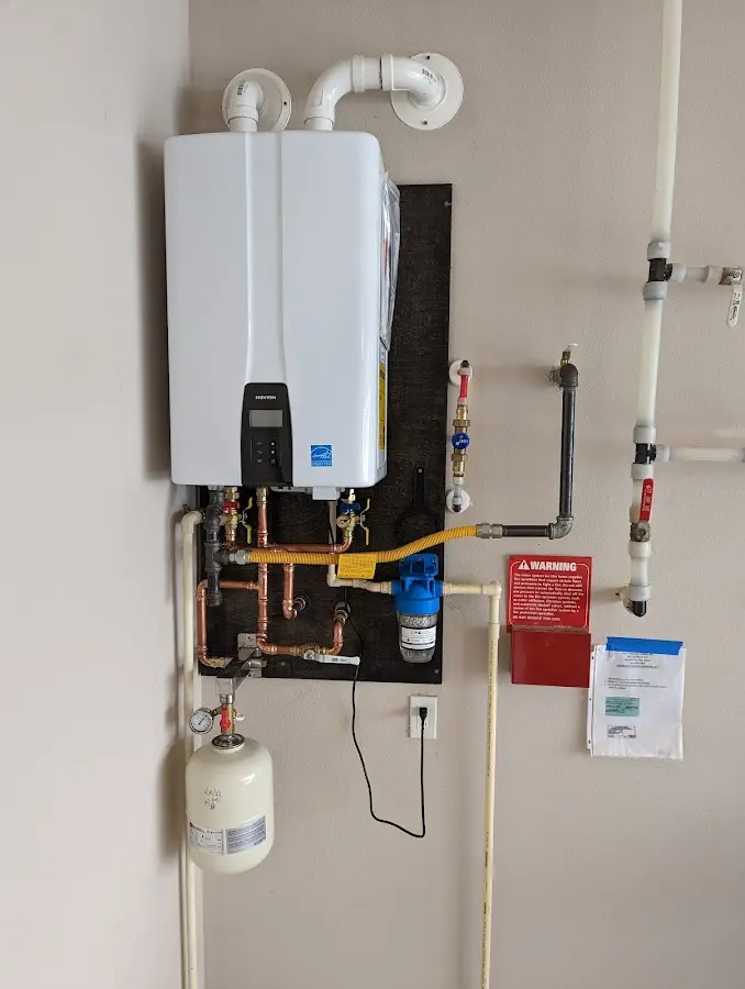 Professional plumber installing copper piping in a Roy home